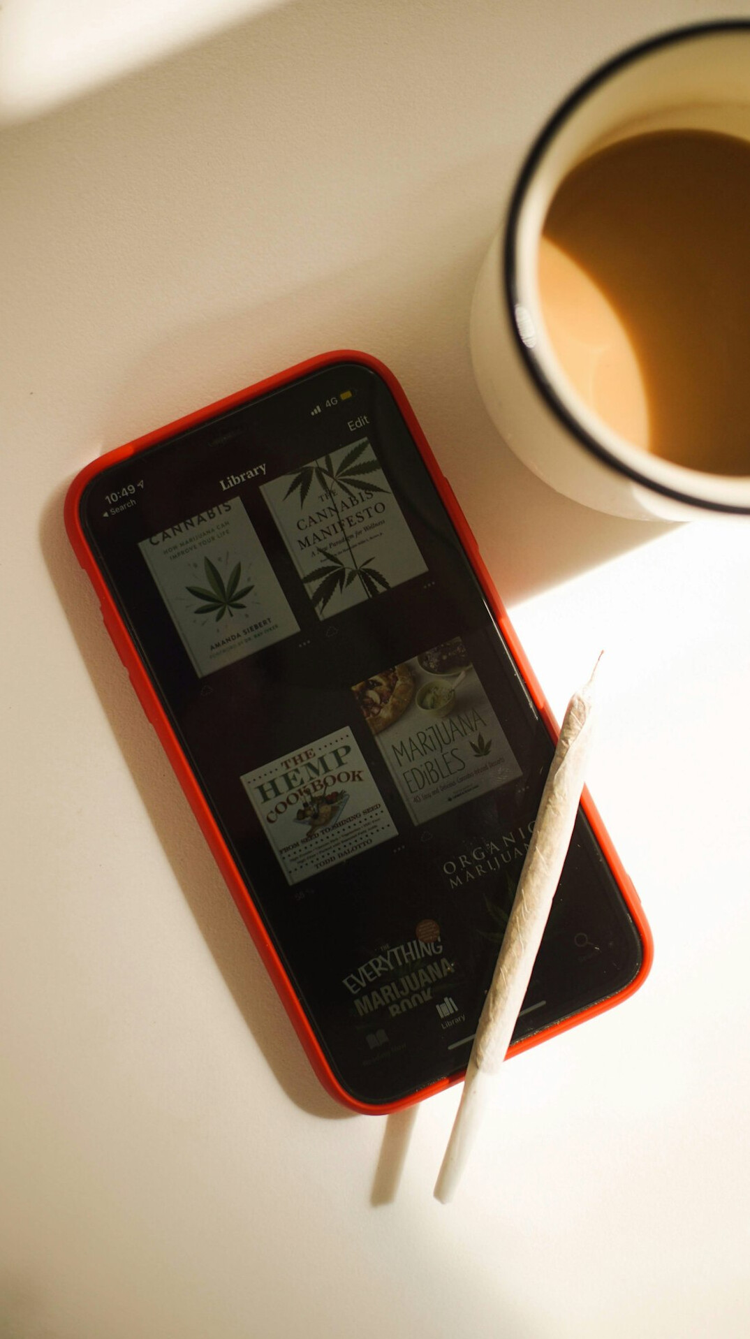 Tablet showing a reading list beside a notebook and tea