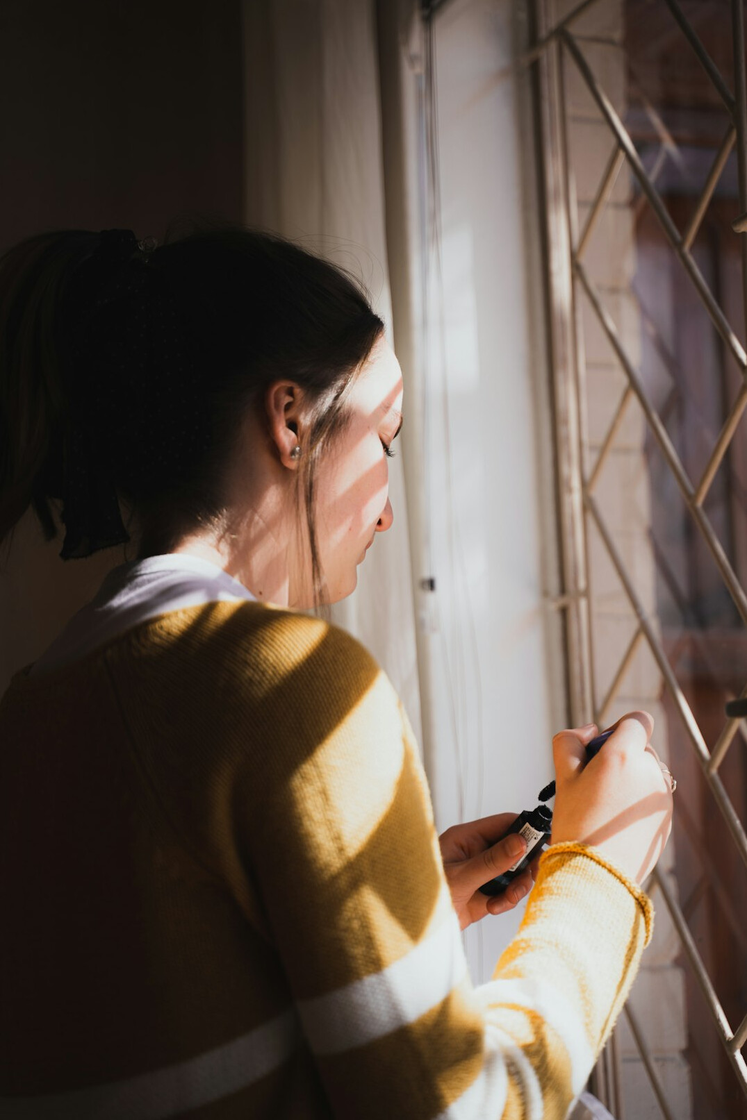 woman knitting by window